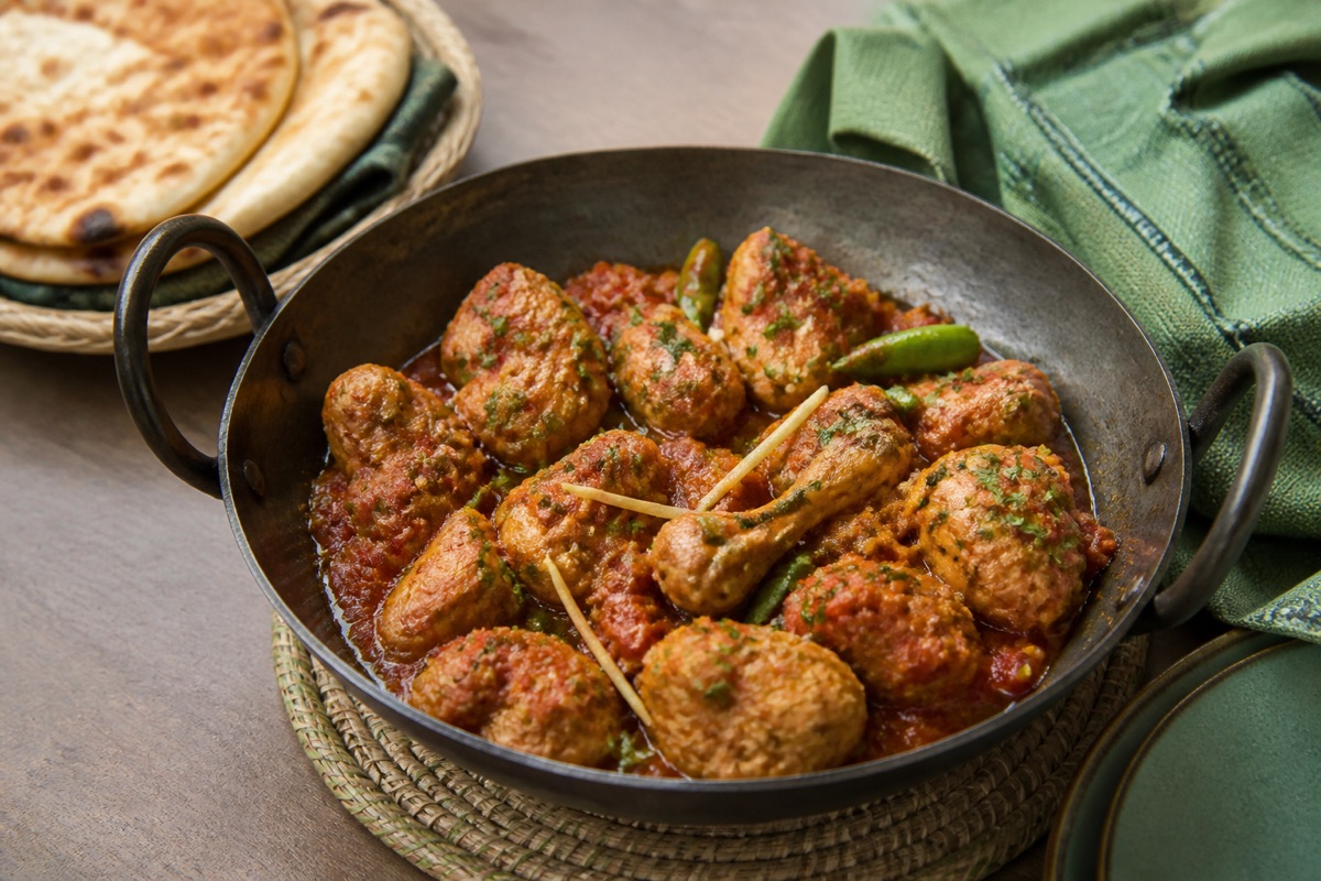 Pakistanische Chicken Karahi mit Tomaten, Ingwer und grünen Chilis in einer Metallschale
